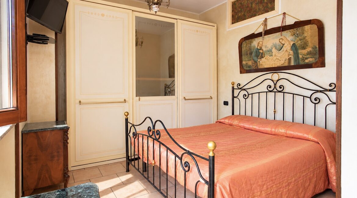 Camera da letto classica con letto in ferro battuto